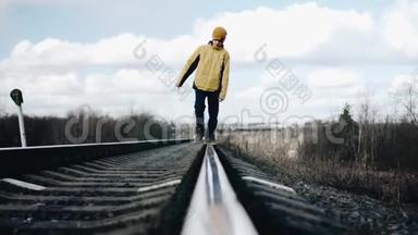 那个男孩在铁轨上行走。 从铁轨上直接看到美丽的景色。 冷静的镜头